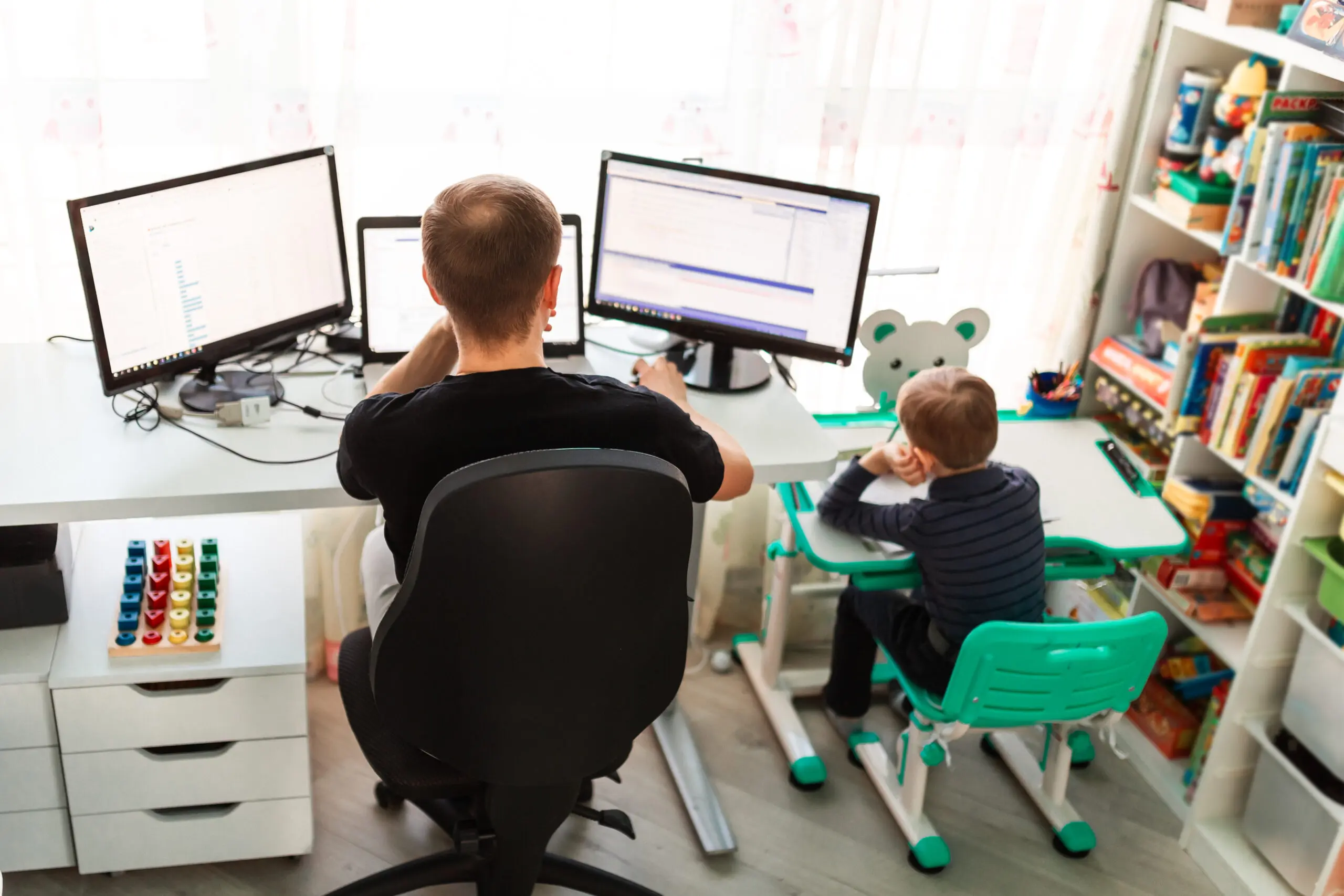 Father with kid working from home during quarantine. Stay at home, work from home concept during coronavirus pandemic