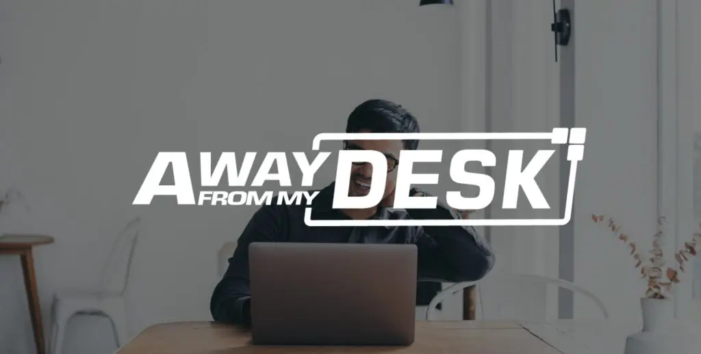 Man smiling on his laptop with the away from my desk logo on top of it