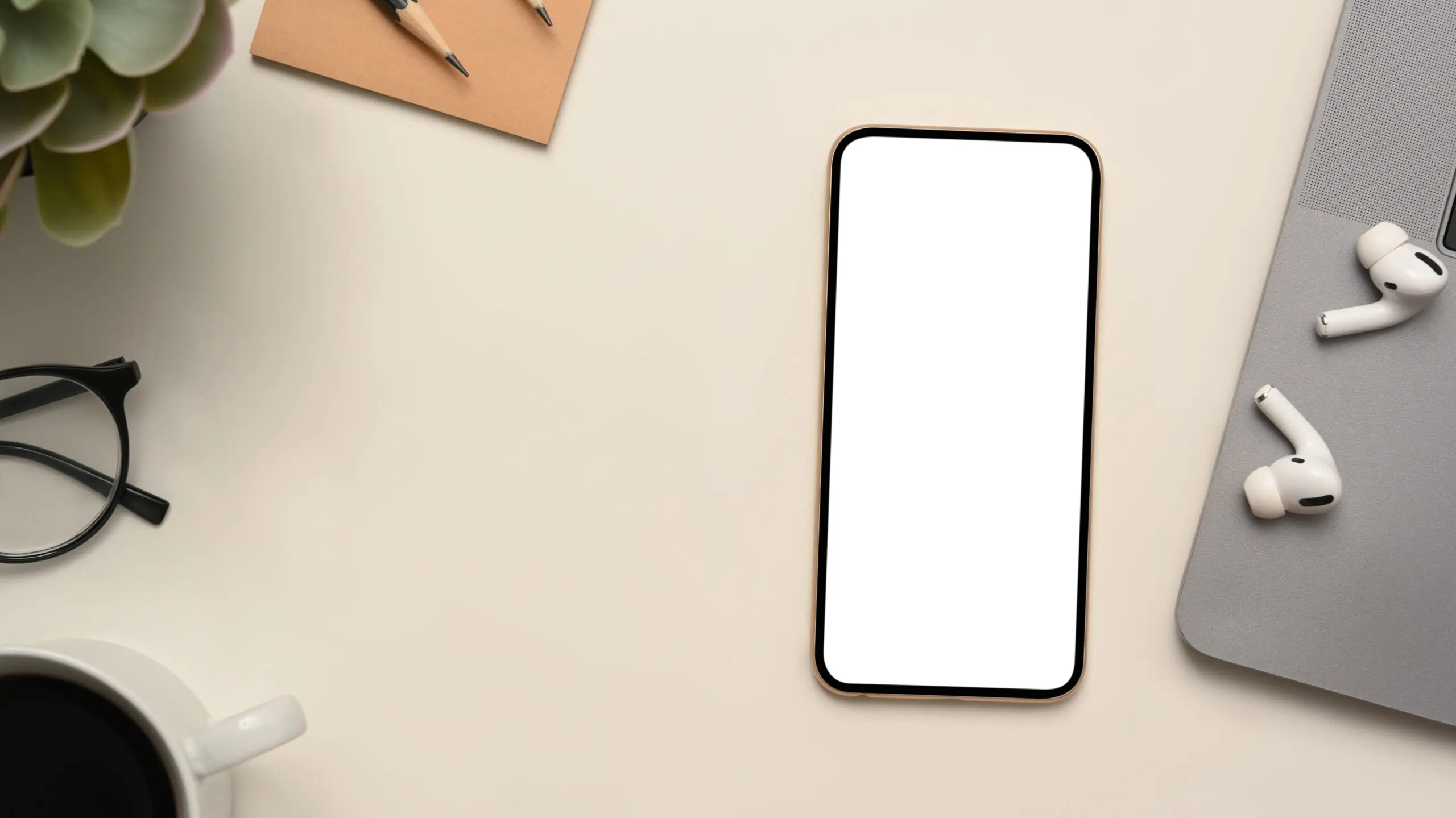 Blank iPhone screen with airpods led down next to them
