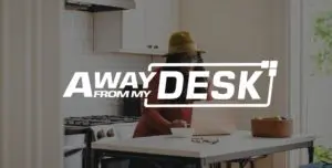 Woman working on her laptop in her kitchen with the away from my desk sign on top of it