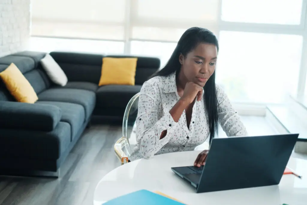 Woman working from home with laptop at the table