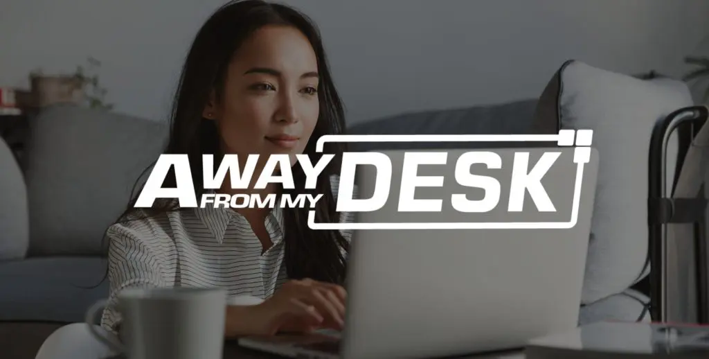 Smiling woman sat down in front of her sofa with her laptop on the table
