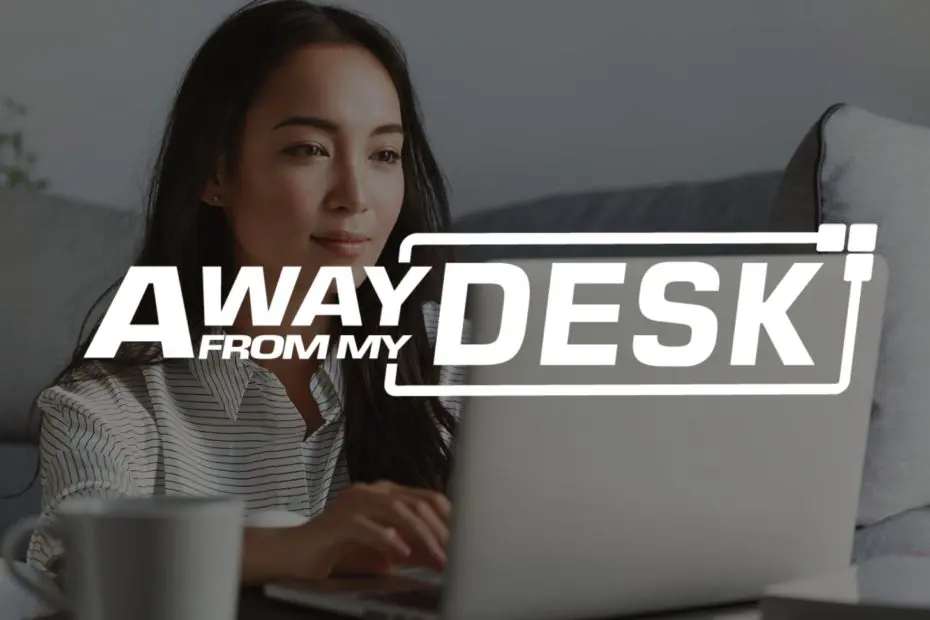 Smiling woman sat down in front of her sofa with her laptop on the table