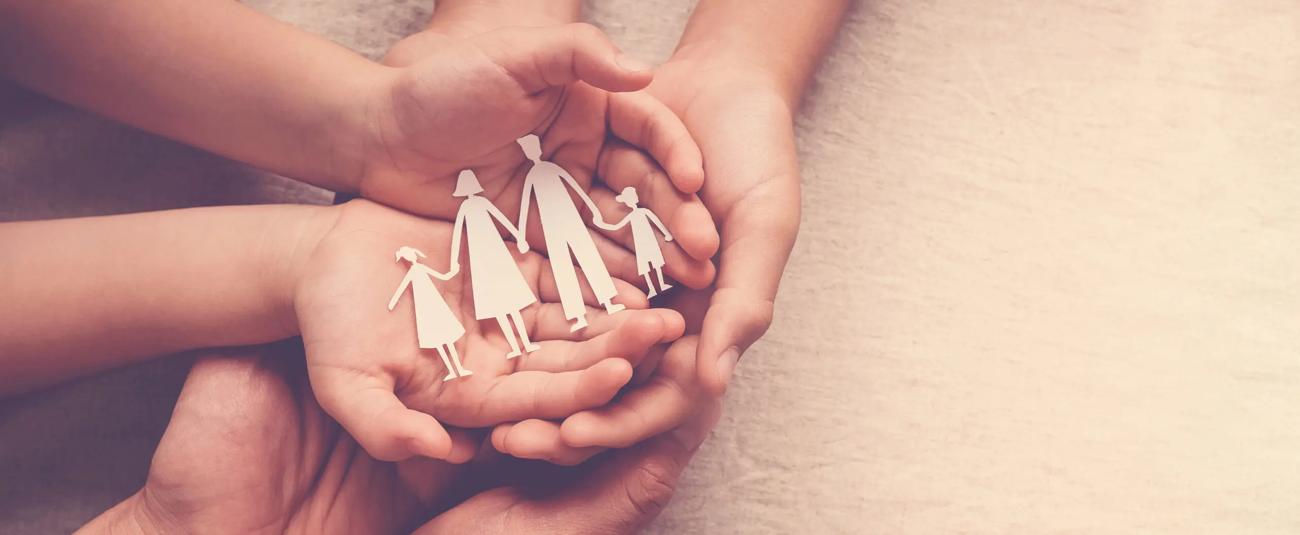 Adult and children hands holding paper family cutout