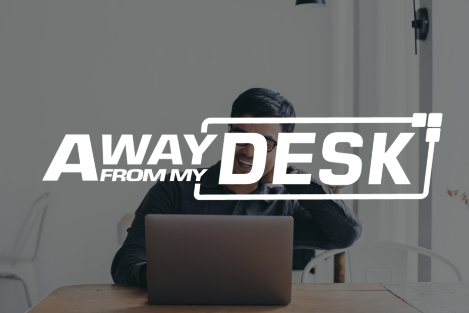 Man smiling on his laptop with the away from my desk logo on top of it